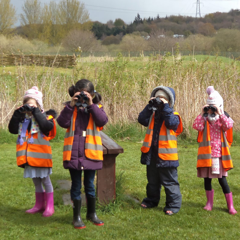 Children learning how to use binoculars